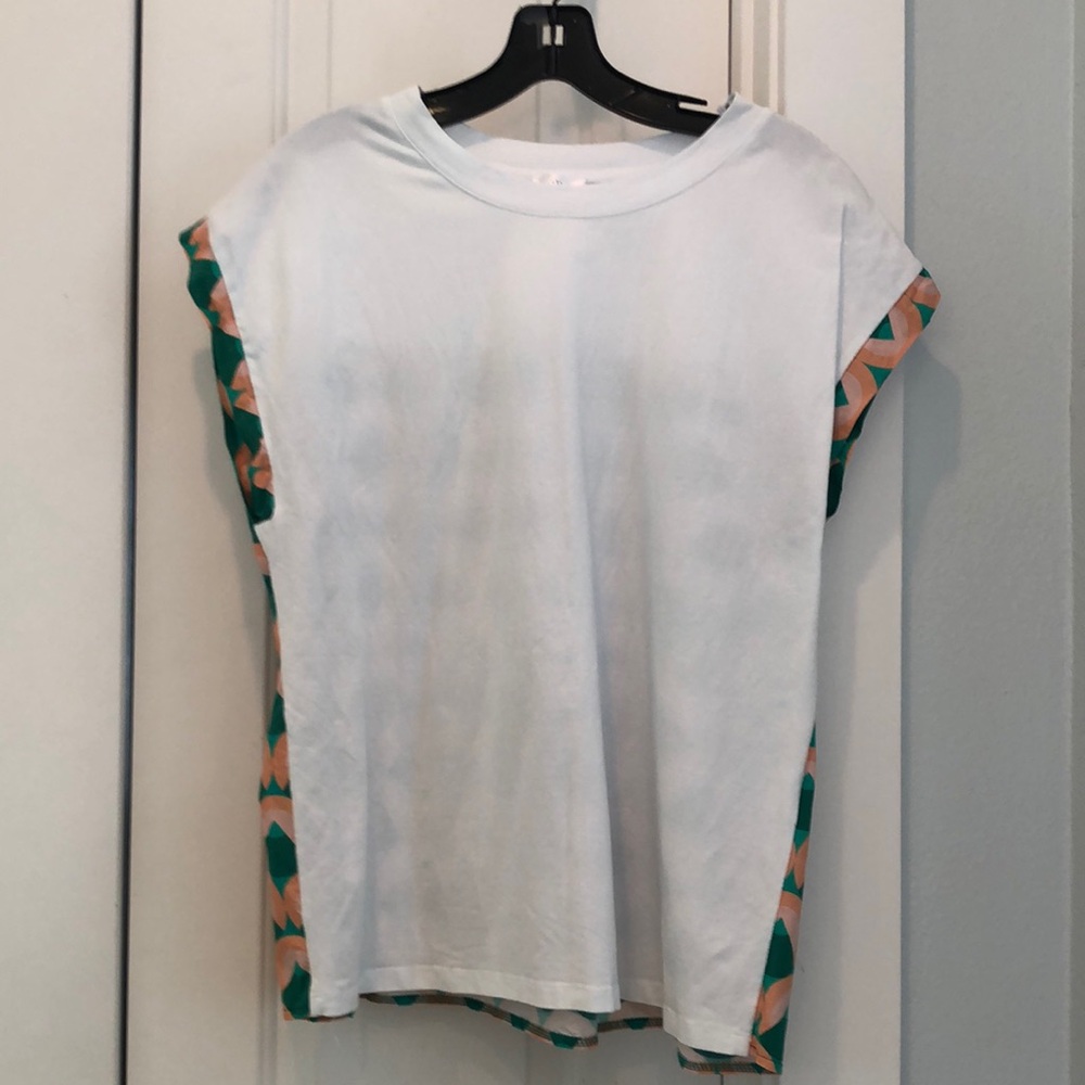 White shirt sleeve top with patterned fabric on sleeve trim and back.